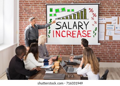 Man Giving Salary Increase Presentation To Colleagues 