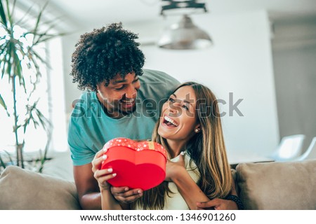 Man giving a surprise gift to woman at home