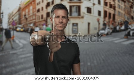 Man giving thumbs down with extended arm and visible thumb on street crosswalk; disapproval critique.