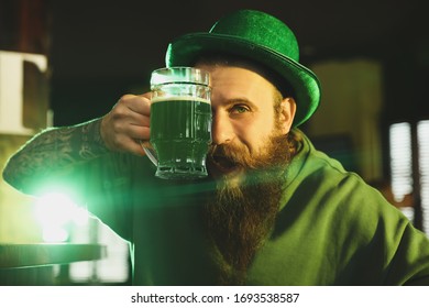 Man With Glass Of Green Beer In Pub. St. Patrick's Day Celebration