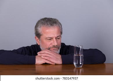 Man With Glass Half Full, Half Empty, Symbolic Image