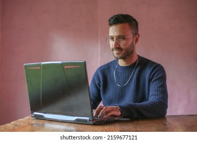 Man With Glasses Smiling Woking From Home On His Laptop