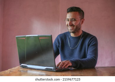 Man With Glasses Smiling Woking From Home On His Laptop