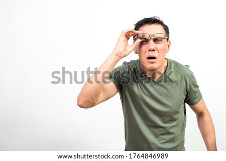 Man with glasses straining his eyes because he can't see well. Mid shot. White background.