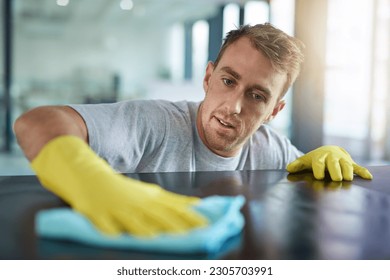 Man with gloves, office cleaning service and janitor dusting dirt for health and hygiene in workplace. Professional cleaner wiping table in workspace, maintenance and disinfectant on cloth for germs. - Powered by Shutterstock