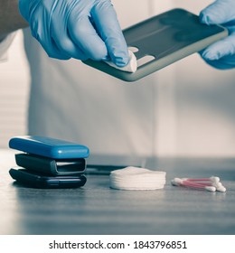 Man In Gloves Wiping Phone Case With Antibacterial Napkin To Avoid Viruses