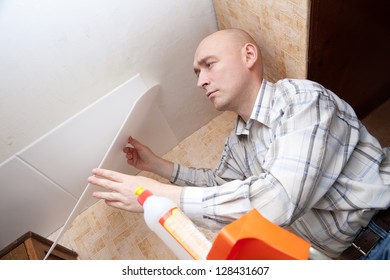 Man Glues Ceiling Tile At Home