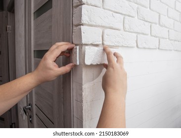 A Man Glues A Decorative Gypsum Stone To The Corner Of A Wall. Decorative Stone In The Form Of A Brick