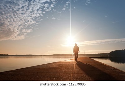 A man goes on the concrete pier in the sunrise - Powered by Shutterstock