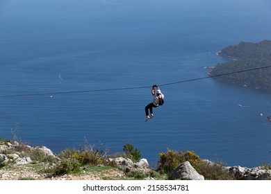 Man going down on rope above Adriatic sea. Adventure attraction near Dubrovnik. Croatia. - Shutterstock ID 2158534781