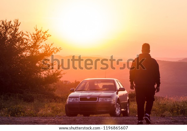 Man going to his car, at sunset, to the mountains.\
old german car.