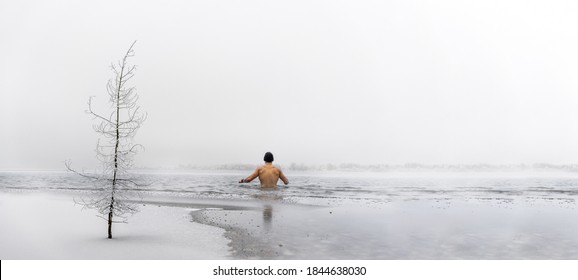 Man Going Ice Swimming Into A Frozen Lake In Winter