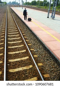 The man going on the empty platform, train departing, view from train, rails to the horizon