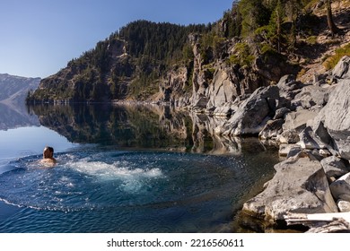 Man Going In For A Swim In Crater Lake NP Oregon In A Beautiful Calm Afternoon, The Cleetwood Cove Trail Leads To The Shore And It Is One Of The Only Places Where Swimming In Allowed.