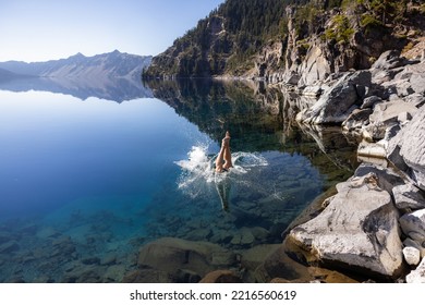 Man Going In For A Swim In Crater Lake NP Oregon In A Beautiful Calm Afternoon, The Cleetwood Cove Trail Leads To The Shore And It Is One Of The Only Places Where Swimming In Allowed.