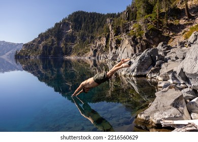 Man Going In For A Swim In Crater Lake NP Oregon In A Beautiful Calm Afternoon, The Cleetwood Cove Trail Leads To The Shore And It Is One Of The Only Places Where Swimming In Allowed.