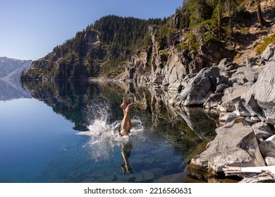 Man Going In For A Swim In Crater Lake NP Oregon In A Beautiful Calm Afternoon, The Cleetwood Cove Trail Leads To The Shore And It Is One Of The Only Places Where Swimming In Allowed.