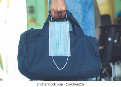 Man Going To Work With Laptop Bag And Protective Mask In Hand. Man With Briefcase And Disposable Face Mask