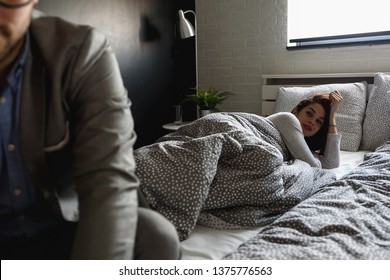 Man Is Going To Work In The Morning Leaving A Woman In The Bed. When Work Interferes With Love.