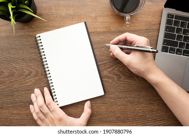 Man is going to write something on blank notebook over wood office table with laptop computer and supplies. Top view, flat lay. - Powered by Shutterstock