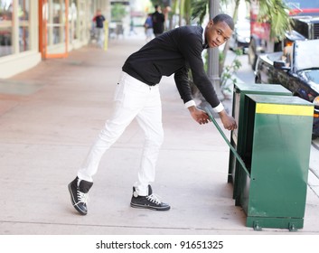 Man Grabbing A Newspaper From The Newspaper Dispenser