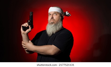 A Man With A Gray Beard With A Gun In His Hands On A Dark Background