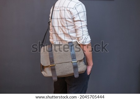 Man with a gray canvas messenger bag. Unisex bag for sale.