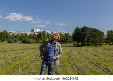 Man in gray jacket posing in park
