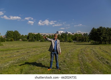 Man in gray jacket posing in park