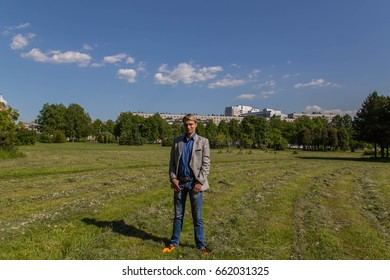 Man in gray jacket posing in park