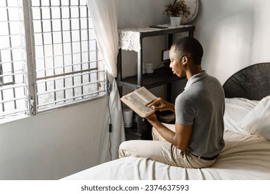 Man in gray shirt reading a book at home. - Powered by Shutterstock