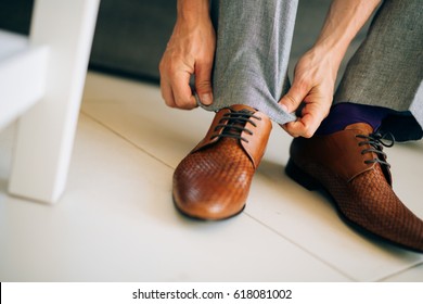 The Man In Gray Slacks And A Purple Dress Socks Brown Shoes With Laces Sitting On The Couch.