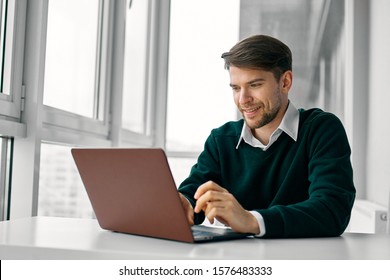 A Man In A Green Sweater In Front Of A Laptop Freelancer