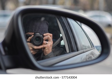 Man In A Grey Cap Takes Photo From A Rear View Mirror Of A Car 