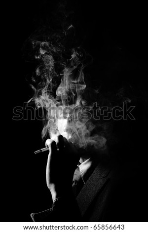 a man in a grey hat on black background smoking a cigarette