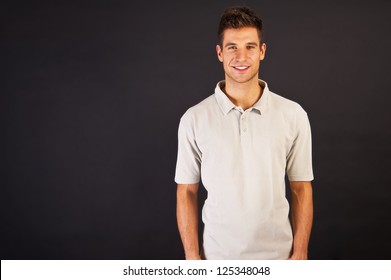 Man In Grey Polo T-shirt On Black Background With Smile