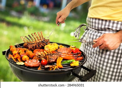 Man Is Grilling Meat On Barbecue For Family Dinner