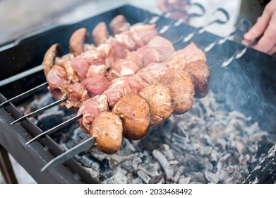 A man grills meat and mushrooms in winter. close-up. Winter picnic, outdoor recreation. defocus 