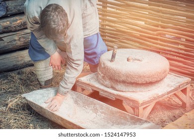 Man To Grind Flour On The Hand Mills. Rustic Life For The Production Of Bread By Grinding Grains Into Flour.