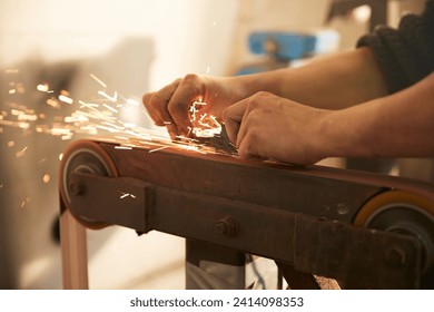 Man grinding a blade in a workshop - Powered by Shutterstock