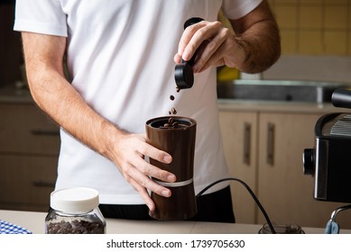 Man Grinding Coffee Beans For Making An Espresso. Home Barista Indoors Lifestyle Concept