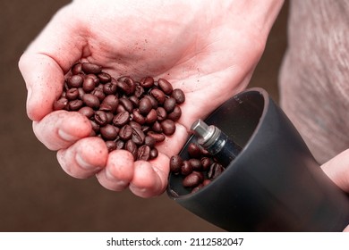 a man grinds coffee in a manual coffee grinder to pour coffee beans into a coffee grinder close-up. High quality photo - Powered by Shutterstock