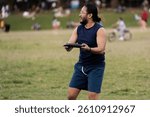 A man grips the Frisbee firmly with both hands, his stance steady and focused, preparing to release it with precision for an upcoming throw. His posture reflects concentration and anticipation.