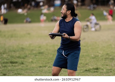 A man grips the Frisbee firmly with both hands, his stance steady and focused, preparing to release it with precision for an upcoming throw. His posture reflects concentration and anticipation.