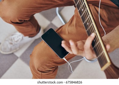 Man With Guitar, Headphones, Phone                               