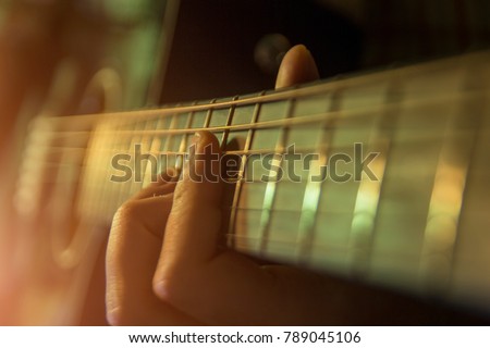 Man with guitar, male hand playing on acoustic guitar. Close-up.