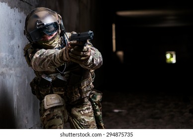 Man with a gun in his hand and military camouflage aiming from his gun