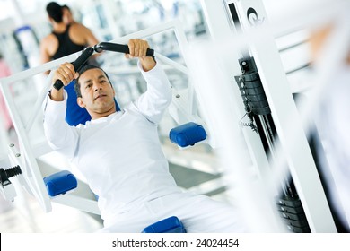 man at the gym doing exercises on a machine