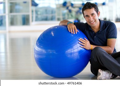 Man At The Gym Leaning On A Pilates Ball And Smiling