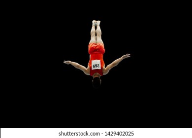 Man Gymnast Flying In Air Somersault Exercise On Black Background